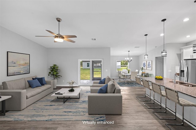 living room with lofted ceiling, sink, ceiling fan with notable chandelier, and dark hardwood / wood-style flooring