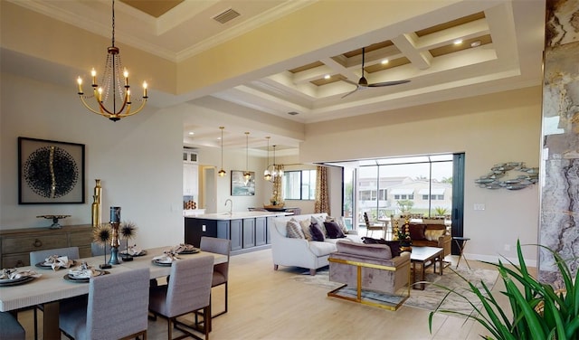 dining space featuring a towering ceiling, crown molding, coffered ceiling, ceiling fan with notable chandelier, and light wood-type flooring