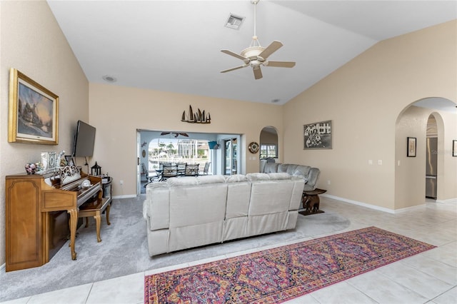 living room with ceiling fan, light tile patterned floors, and vaulted ceiling