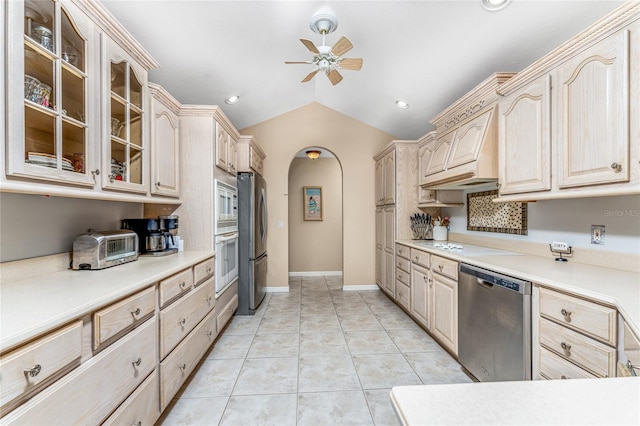 kitchen with ceiling fan, vaulted ceiling, light brown cabinetry, light tile patterned flooring, and appliances with stainless steel finishes