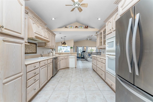 kitchen featuring light tile patterned floors, light brown cabinetry, appliances with stainless steel finishes, and vaulted ceiling