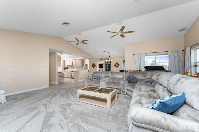 carpeted living room with ceiling fan with notable chandelier and lofted ceiling