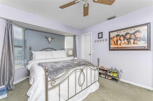 carpeted bedroom with ceiling fan and a textured ceiling