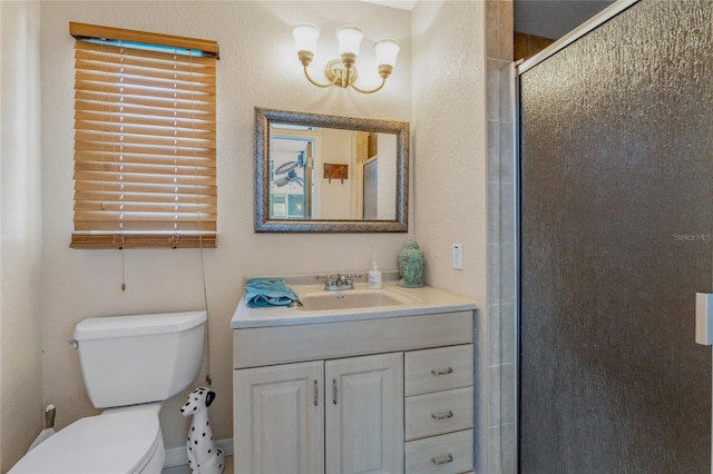 bathroom featuring vanity, a shower with shower door, and toilet