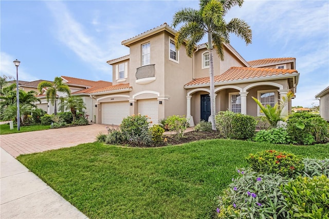 mediterranean / spanish-style home featuring a front lawn and a garage