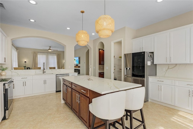 kitchen featuring ceiling fan, sink, white cabinets, light tile flooring, and decorative light fixtures