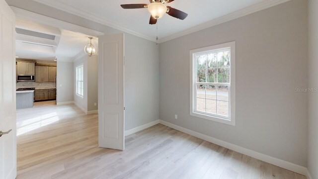 spare room with beam ceiling, ornamental molding, ceiling fan, and light wood-type flooring