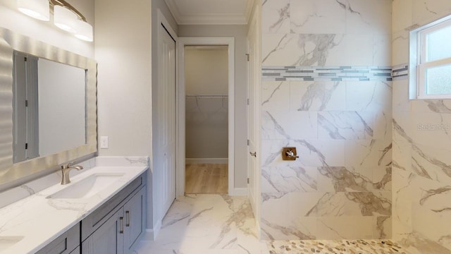 bathroom with crown molding, a tile shower, and vanity