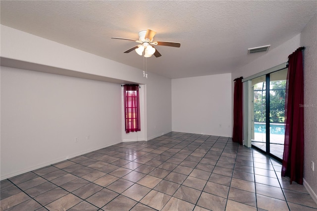 unfurnished room with tile patterned flooring, ceiling fan, and a textured ceiling