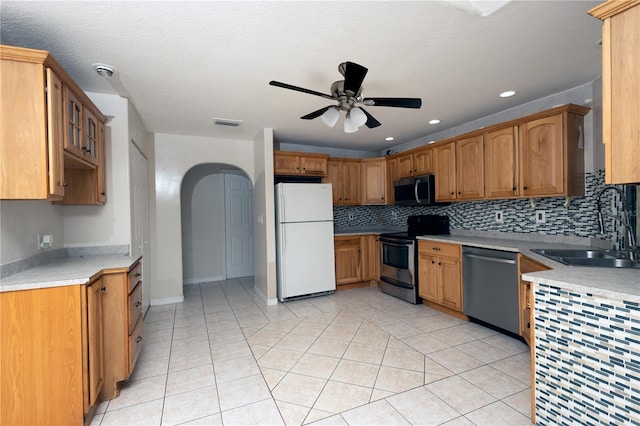 kitchen with tasteful backsplash, sink, appliances with stainless steel finishes, light tile patterned floors, and ceiling fan