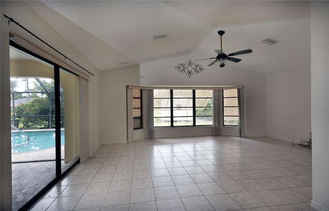 tiled empty room with lofted ceiling, ceiling fan, and plenty of natural light