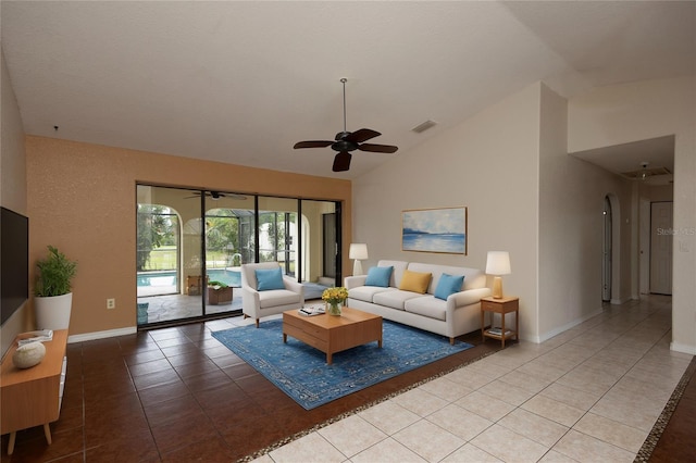 tiled living room with ceiling fan and high vaulted ceiling