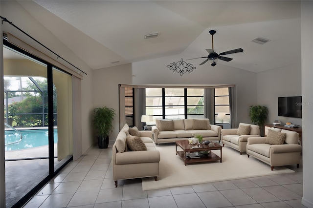 living room featuring ceiling fan, lofted ceiling, plenty of natural light, and light tile patterned floors