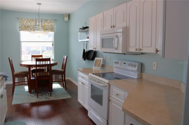 kitchen with white appliances, white cabinetry, dark wood-type flooring, and hanging light fixtures