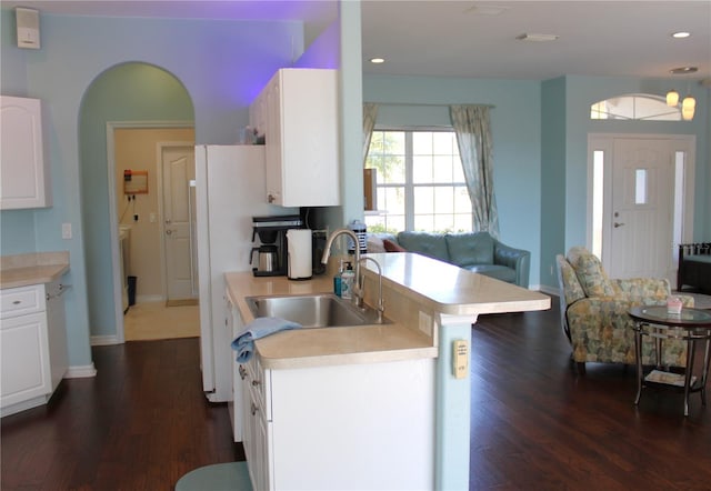 kitchen featuring white cabinets, sink, a kitchen bar, and dark hardwood / wood-style flooring