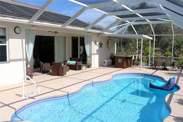 view of pool with an outdoor bar, a patio, glass enclosure, and ceiling fan