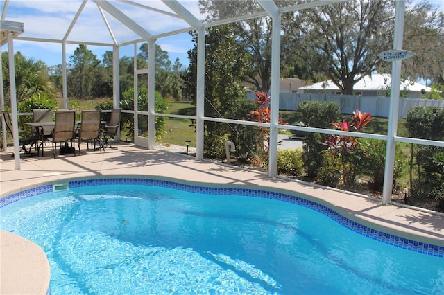 view of swimming pool with a patio area and glass enclosure