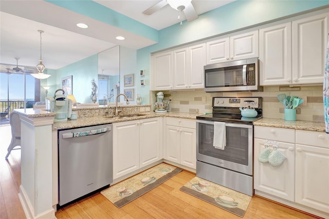 kitchen with ceiling fan, light hardwood / wood-style floors, appliances with stainless steel finishes, and kitchen peninsula