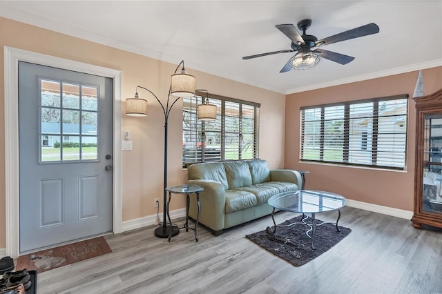 living room featuring light hardwood / wood-style floors, a wealth of natural light, ornamental molding, and ceiling fan