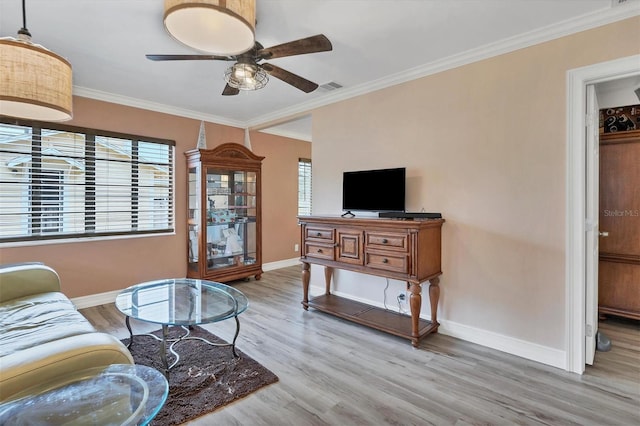 living room with crown molding, ceiling fan, and light wood-type flooring