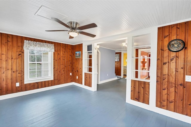 unfurnished room with wooden walls, crown molding, ceiling fan, and dark hardwood / wood-style floors