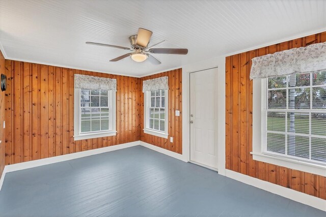 spare room with ceiling fan, wood walls, and dark hardwood / wood-style floors