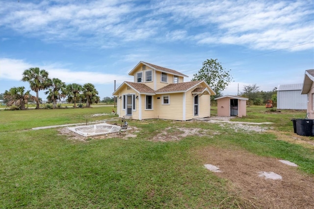 rear view of property with a lawn and a storage shed