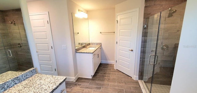 bathroom with a shower with door and vanity