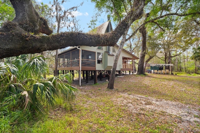 back of property featuring a sunroom and a carport