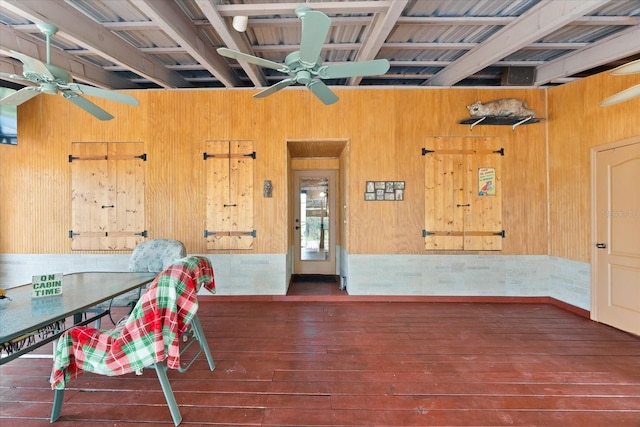 unfurnished dining area featuring wooden walls and dark hardwood / wood-style floors