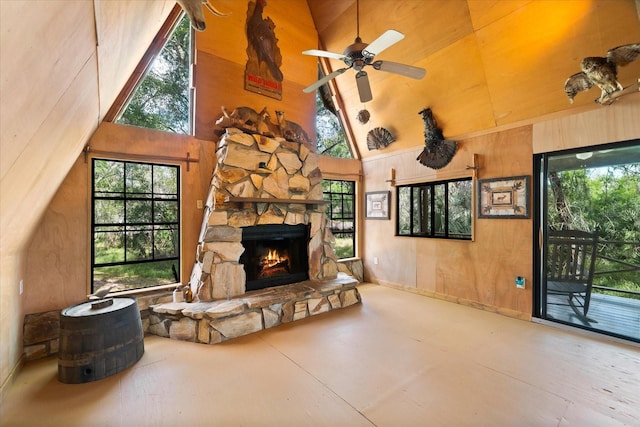 living room featuring plenty of natural light, a stone fireplace, and high vaulted ceiling