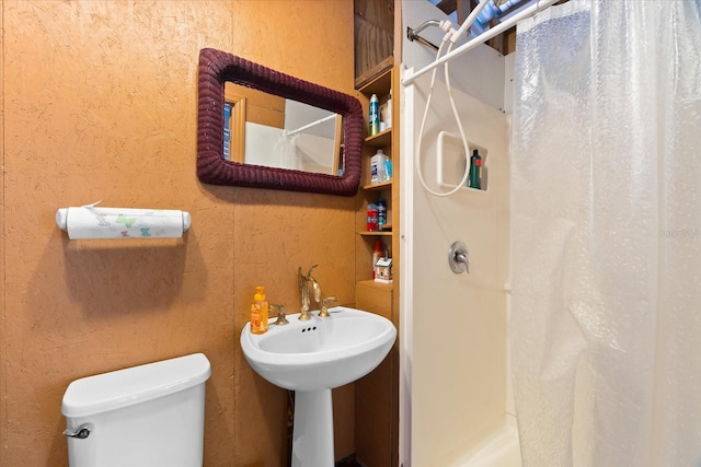 bathroom featuring a shower with curtain, toilet, and sink