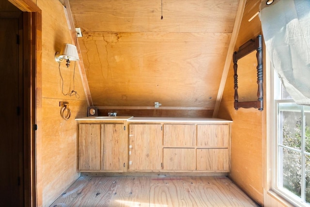 bathroom with hardwood / wood-style flooring, lofted ceiling, and wood walls