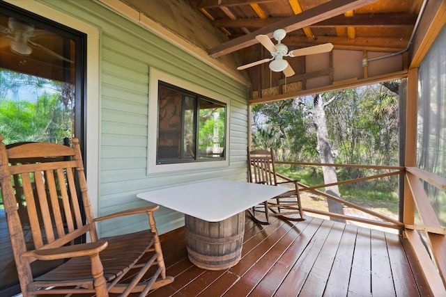 sunroom / solarium featuring lofted ceiling with beams, ceiling fan, and wooden ceiling