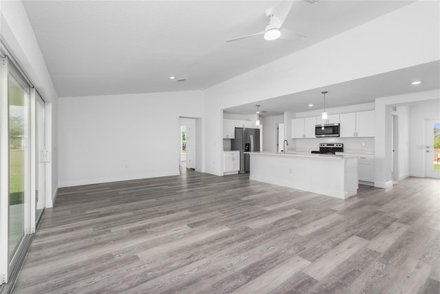 unfurnished living room with light wood-type flooring, baseboards, vaulted ceiling, and a ceiling fan