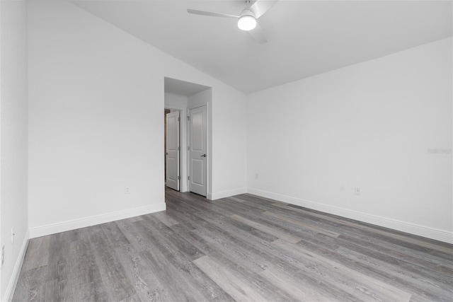 spare room featuring a ceiling fan, light wood-style flooring, and baseboards