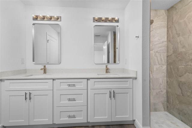 full bathroom with a walk in shower, double vanity, and a sink