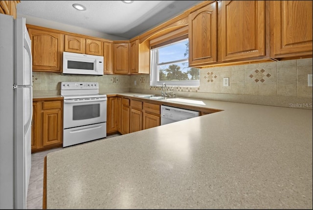 kitchen with white appliances, backsplash, sink, and light tile floors