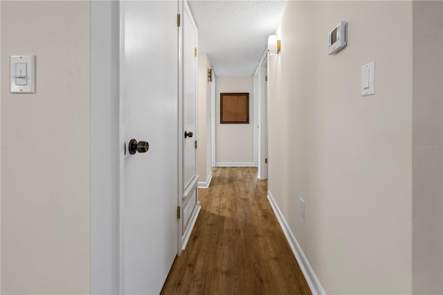 hallway with light hardwood / wood-style flooring and a textured ceiling