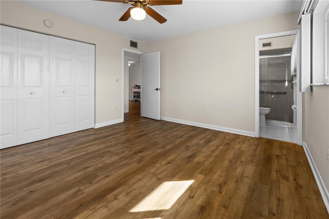 unfurnished bedroom with ensuite bathroom, a closet, ceiling fan, and dark hardwood / wood-style flooring