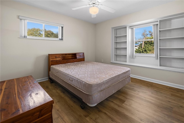 bedroom with ceiling fan, multiple windows, and dark wood-type flooring