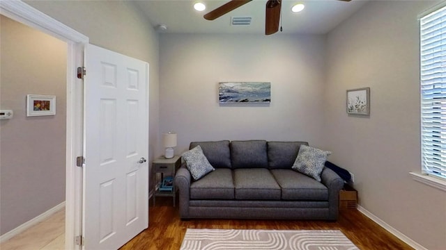 living room featuring dark hardwood / wood-style floors and ceiling fan