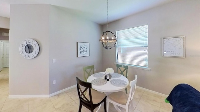 tiled dining room featuring an inviting chandelier and a healthy amount of sunlight