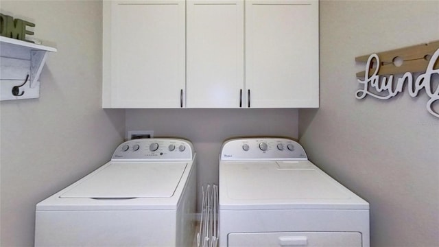 washroom with cabinets and washer and clothes dryer