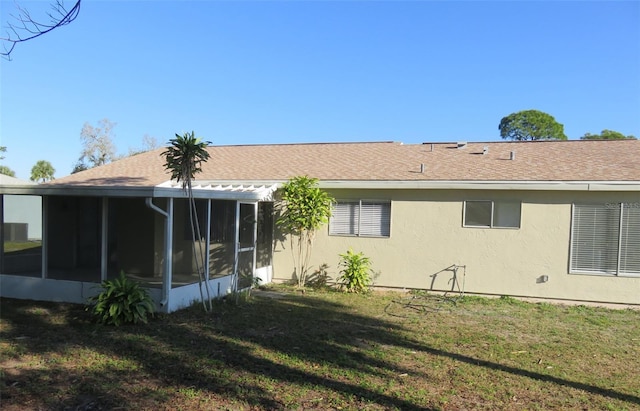 back of property with a yard and a sunroom