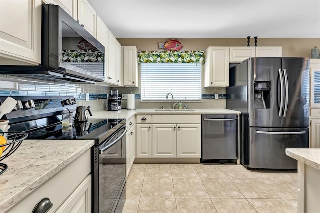 kitchen featuring light stone countertops, backsplash, light tile flooring, sink, and stainless steel appliances