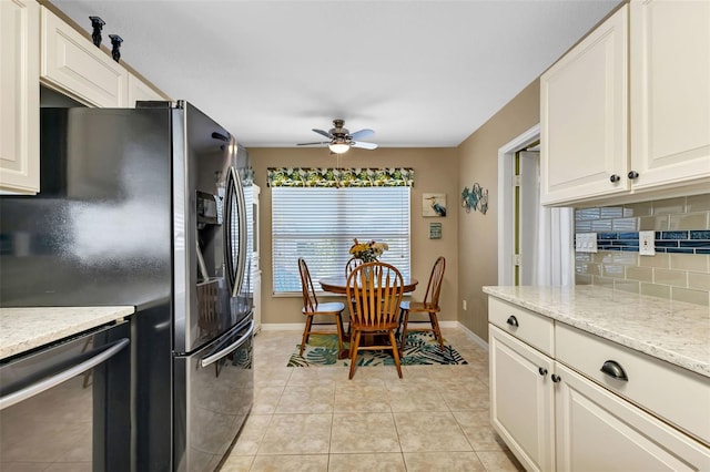 kitchen featuring backsplash, ceiling fan, light tile flooring, stainless steel dishwasher, and light stone counters