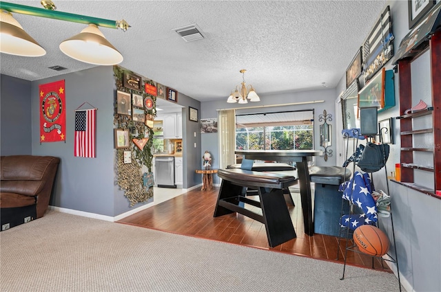 dining area with hardwood / wood-style flooring, a chandelier, and a textured ceiling