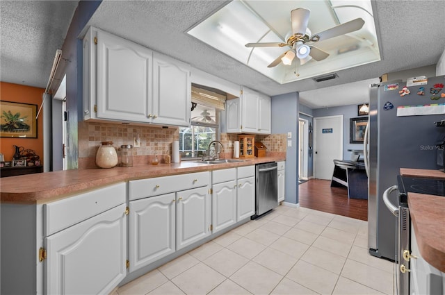 kitchen featuring white cabinetry, appliances with stainless steel finishes, sink, and ceiling fan