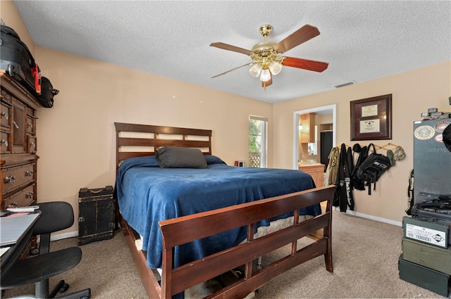 bedroom with ceiling fan, ensuite bath, a textured ceiling, and light colored carpet